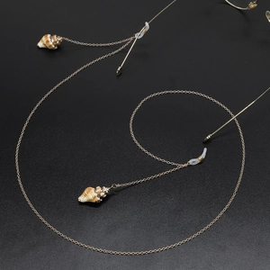 Golden handmade glasses chain featuring natural sea shells on a minimalist metal link cord