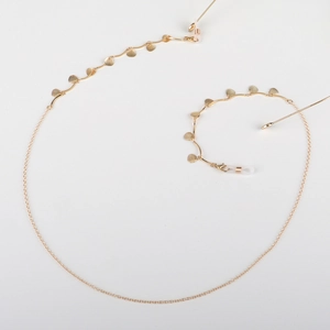 Golden chain eyeglass strap with shell charms on a white background, versatile accessory