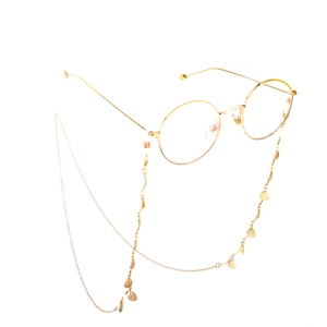 Fashionable golden round metal glasses with leaf pendant decorative chain on white background