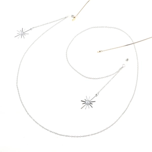 Detail of silver eyewear chain featuring snowflake pendants and white pearl accents