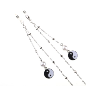 Silver metal glasses chain with pearls and Tai Chi pendant on white background