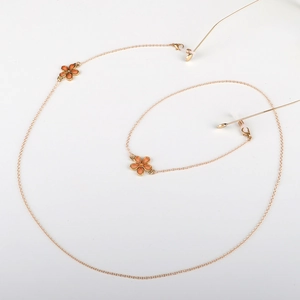 Chaîne de lunettes dorée avec pendentifs fleurs orange et boucles en silicone antidérapantes