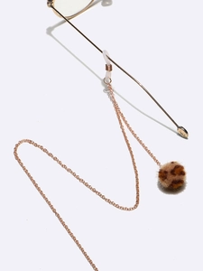 Detalle de cadena de metal dorado para gafas con pompones de pelo sintético de leopardo