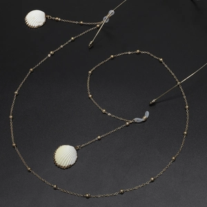 Elegant gold metal eyewear chain with natural white shell pendants on a black background