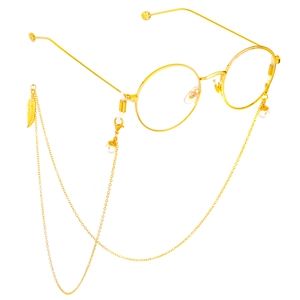 Detail of gold metal eyewear chain with white pearls and a feather pendant on glasses