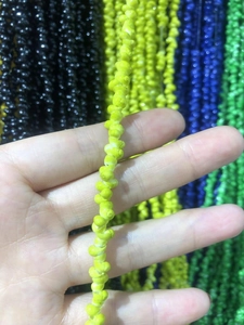 Detailed macro view of yellow spiral seashell beads on a stylish eyewear chain accessory