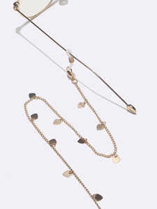 Détail de chaîne à lunettes dorée avec breloques cœur et boucles en silicone antidérapantes