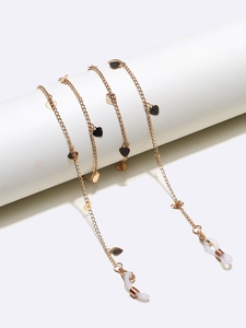 Détail d'une chaîne de lunettes dorée avec pendentifs cœur et embouts antidérapants