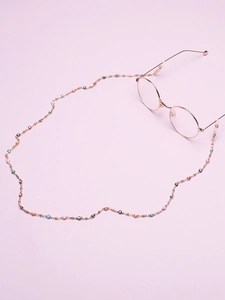 Detailed close-up of golden glasses chain with colorful evil eye beads and silicone loops