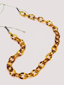 Detail of tortoise shell acrylic eyeglass chain with large amber link rings and grips