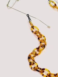Detail of tortoise shell acrylic eyeglass chain connected to silver frames