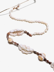 Detail of natural seashell eyewear chain with gold lobster clasp and beach-style beads