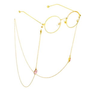 Detail der goldenen Brillenkette mit rosa Tropfenanhängern an runder Metallbrille