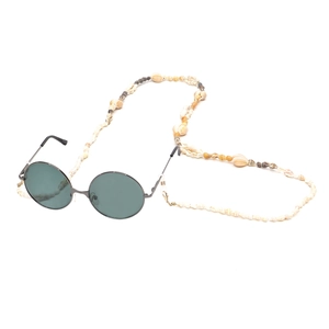 Retro round sunglasses with a unique natural seashell strap on a clean white background