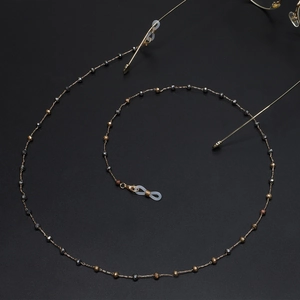 Handmade gold eyewear chain with crystal beads and non-slip loops on black background