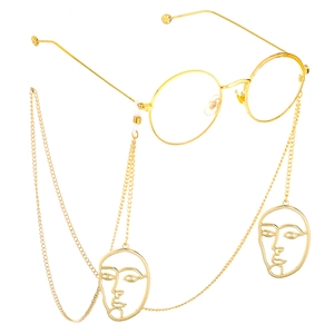 Detail of gold metal glasses chain featuring unique abstract face silhouette pendants