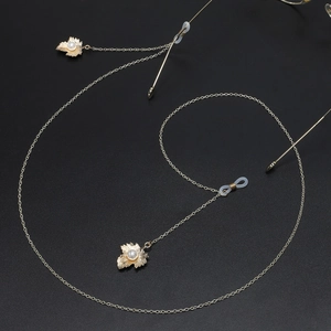 Golden metal eyewear chain with maple leaf charms and white pearls on black background