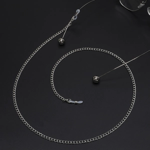 Silver metal eyewear chain with adjustable loops and spherical pendants on black background