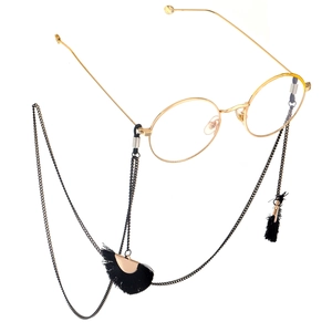 Fashionable gold round metal glasses with black tassel fan pendant chain on white background