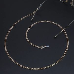 Elegant gold metal eyeglass chain with spiral design on black textured background