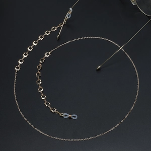 Golden square chain eyewear strap with non-slip silicone loops on black background