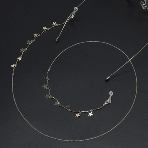 Chaîne de lunettes dorée élégante avec étoiles pour lunettes sur fond noir profond