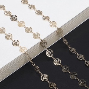 Golden Tree of Life eyewear chain with handmade hollow pendants on a minimalist background