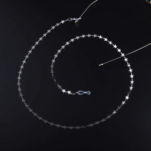 Détail de la chaîne de lunettes à étoiles argentées avec attaches en silicone sur fond noir