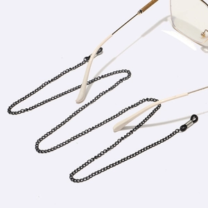 Détail de chaîne de lunettes en métal noir avec boucles silicone sur monture dorée