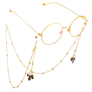 Golden eyeglass chain with white pearls and grey crystals on round glasses