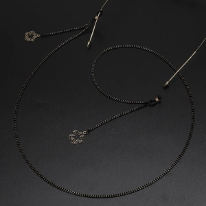 Fashionable black eyewear chain with gold flower pendants and rubber loops