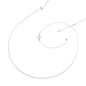 Detail of gold metal glasses chain featuring a white floral pendant and rubber loops
