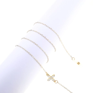 Detail of gold metal glasses chain featuring a white floral pendant and silicone loops