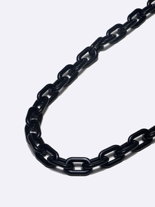 Minimalist black acrylic eyewear chain featuring high-gloss resin oval links on gray