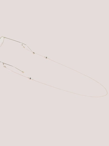 Detailed shot of golden metal glasses chain with white pearls and anti-slip silicone loops