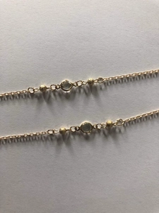 Detailed macro view of 70cm gold glasses chain with glass beads and crystal setting