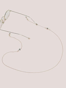 Detail of gold metal eyewear chain featuring white pearls and clear anti-slip rubber loops
