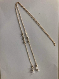 Detailed view of golden copper eyewear chain with clear crystal beads and rubber loops