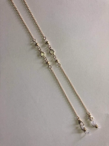 Detail of rose gold eyeglass chain with small beads and crystal inlaid circular charms
