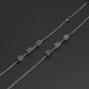 Schicke silberne Metallkette mit quadratischen grauen Marmorperlen auf schwarzem Grund