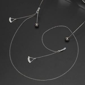 Silver eyewear chain featuring pearl triangle pendant and polished metal spheres