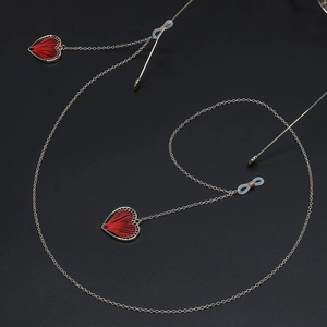 Golden anti-slip eyewear chain featuring red woven heart pendant on black background