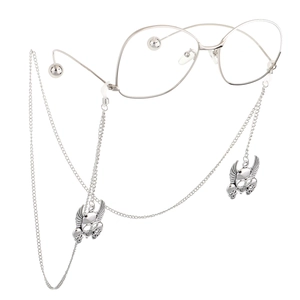 Silver eyewear chain with winged skull pendants and slim frame glasses in punk style