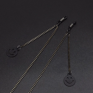 Fashionable black and gold chain glasses strap featuring minimalist hollow smiley pendants