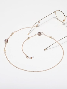 Elegant gold glasses chain with white pearls and rhinestone beads on a white background