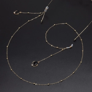 Golden eyeglass chain featuring black round pendants with rhinestones and pearl accents