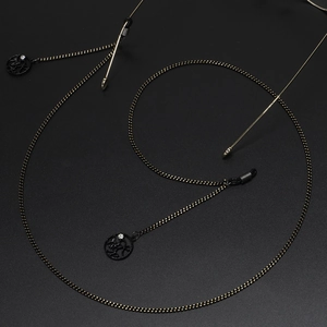Fashionable black and gold eyewear chain with sparkling rhinestone bow pendant detail
