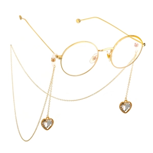 Detailopname van de gouden brillenketting met fonkelende kristallen harthangers