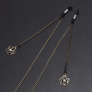 Chaîne de lunettes tressée noire avec pendentif camélia doré et perle élégante