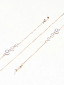 Detailed view of golden eyeglass chain featuring white graduated pearls and lobster clasps
